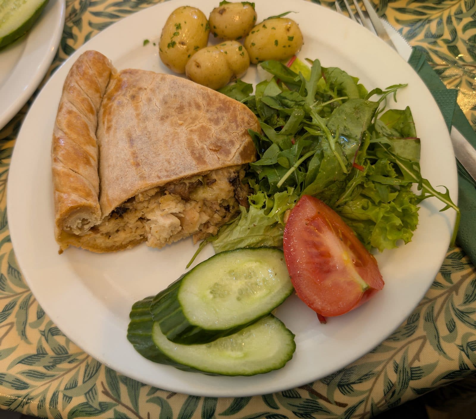 Slice of pastry-topped chicken, leek and mushroom pie with new potatoes and a side salad