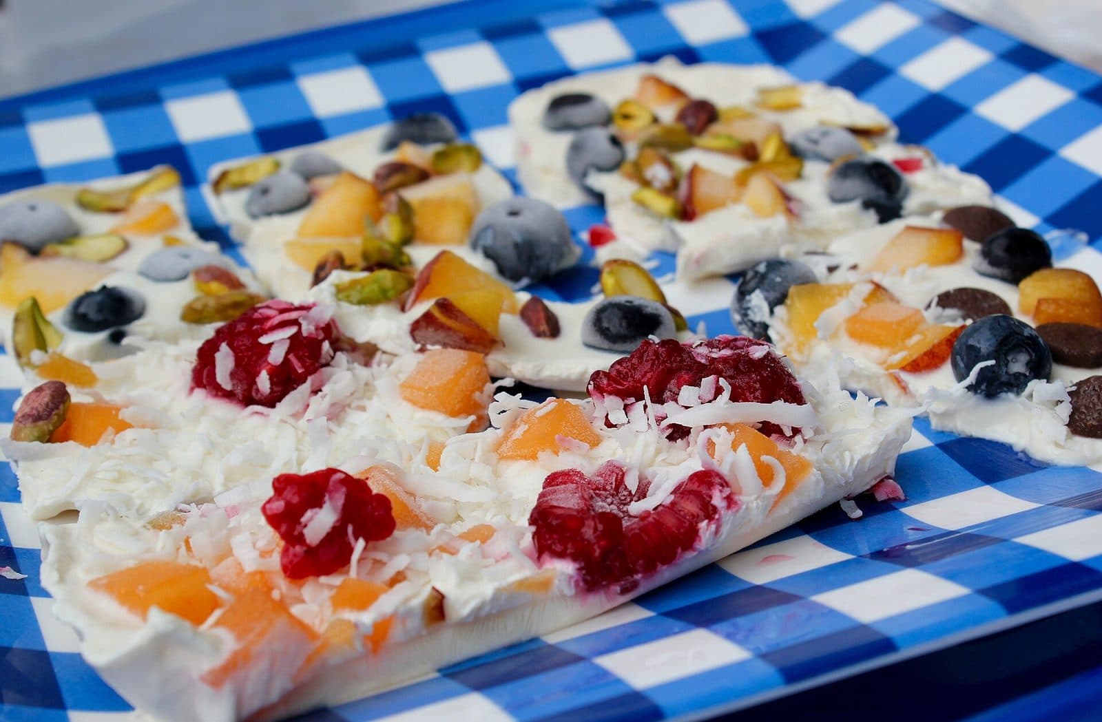Frozen Greek yogurt bark topped with berries, peach, pistachios and coconut