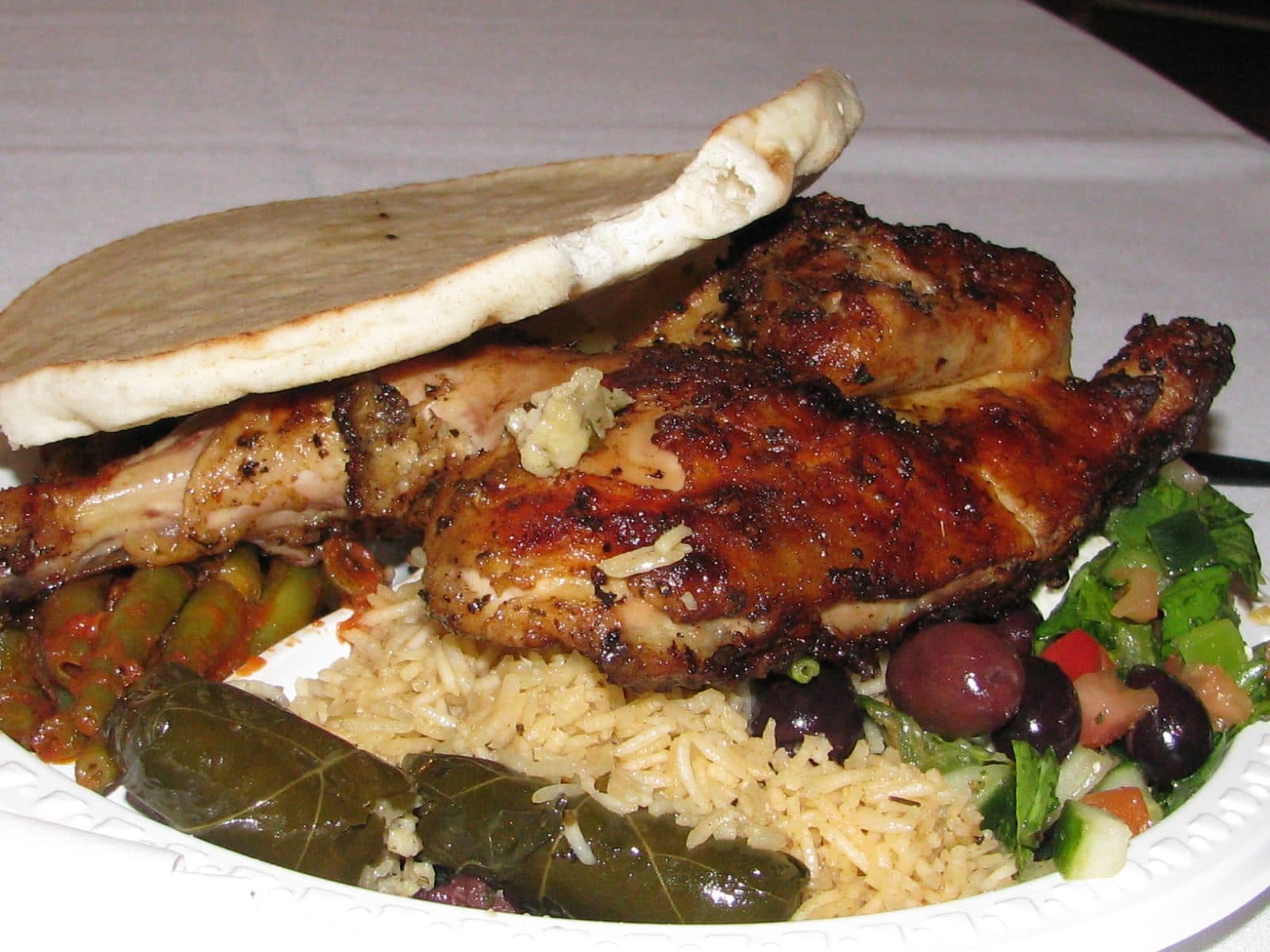 Greek-style roast chicken with rice pilaf, olives, salad, dolmades and pita