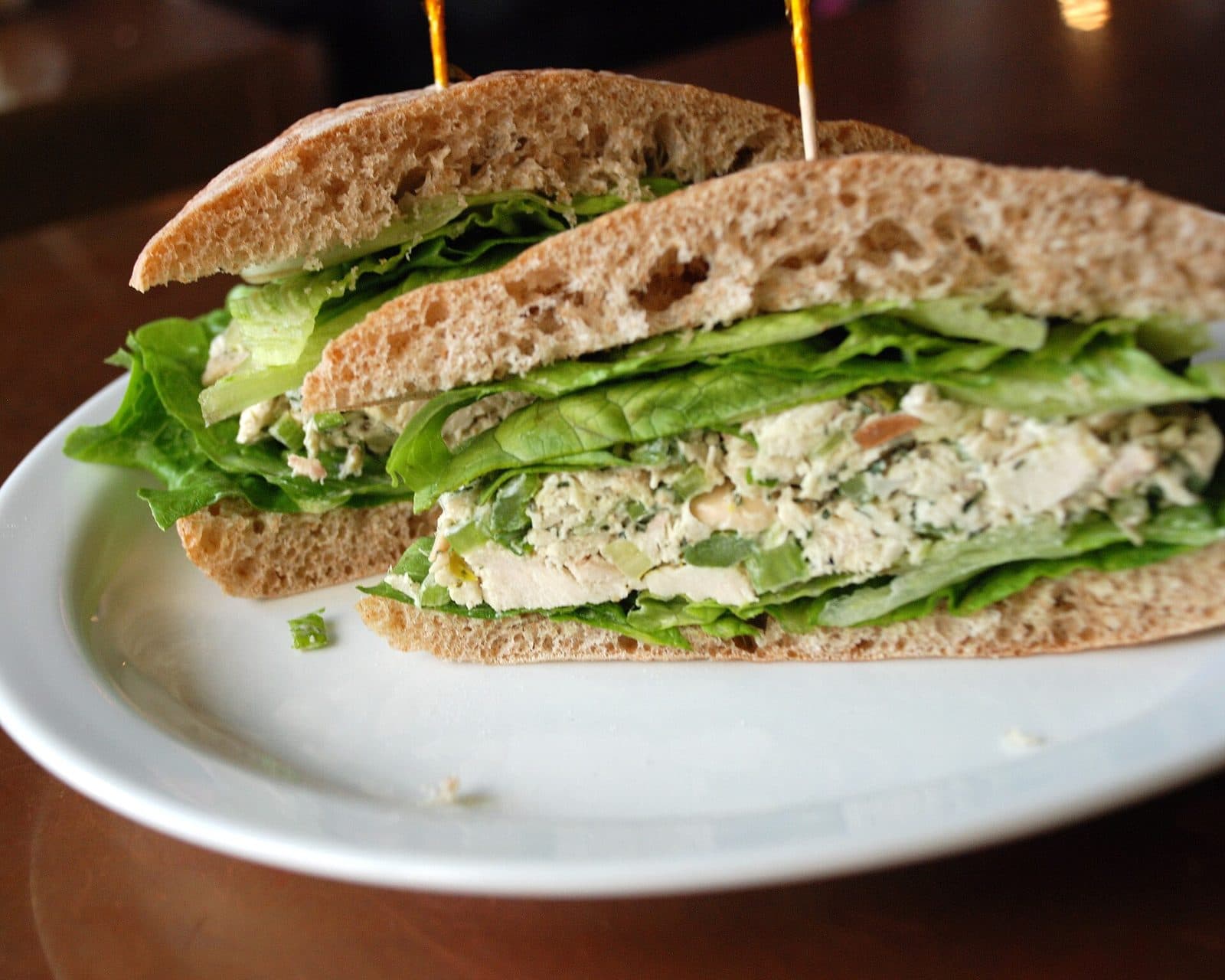 Creamy chicken salad sandwich with lettuce on wholemeal bread, cut in half