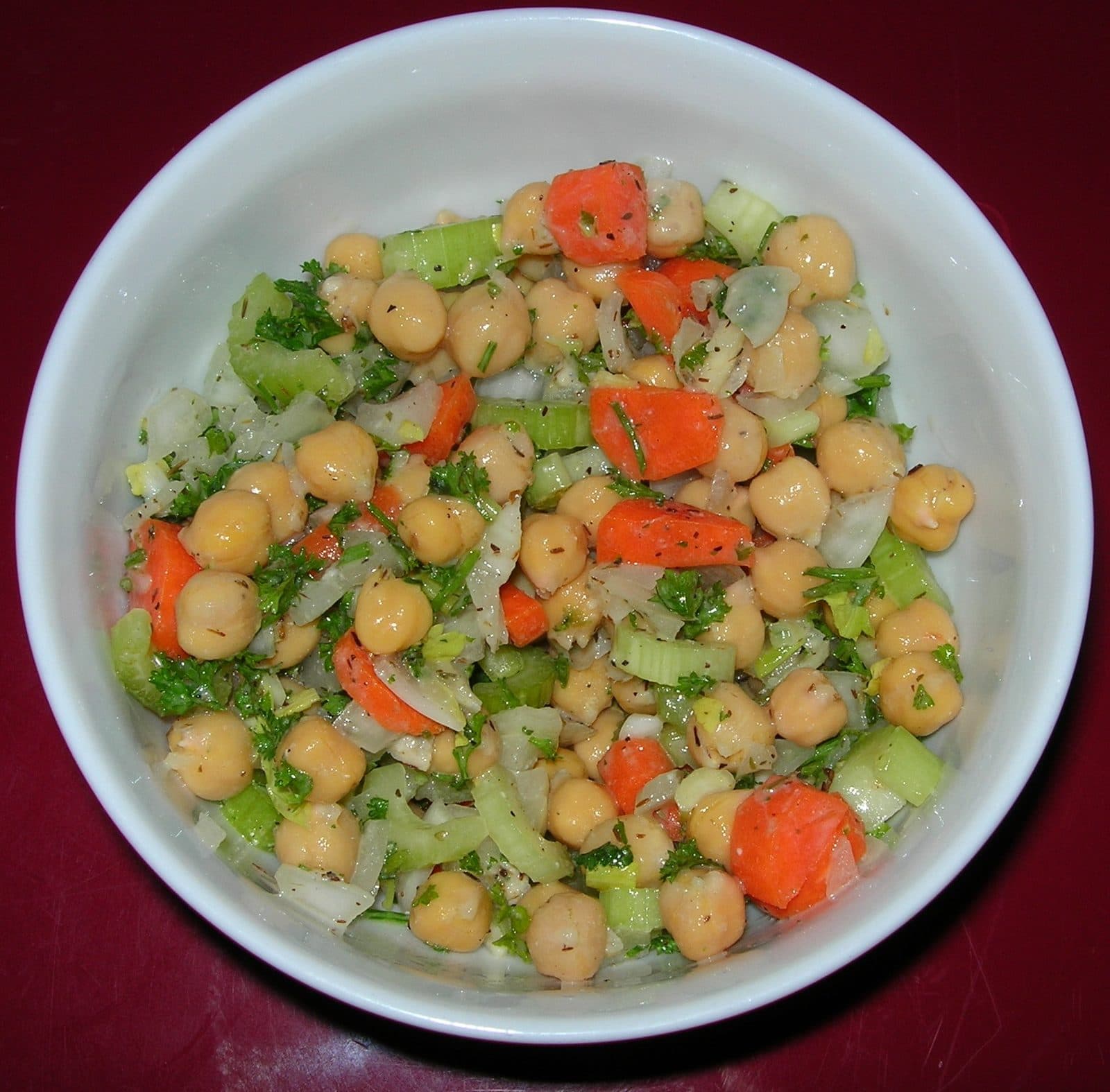 Bowl of chickpea salad with carrot, celery, onion and parsley