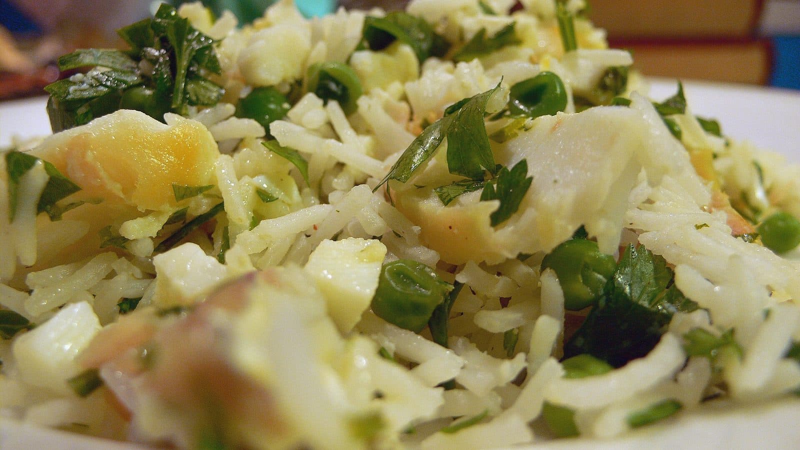 Close-up of kedgeree: rice with flaked smoked fish, egg, peas and fresh herbs
