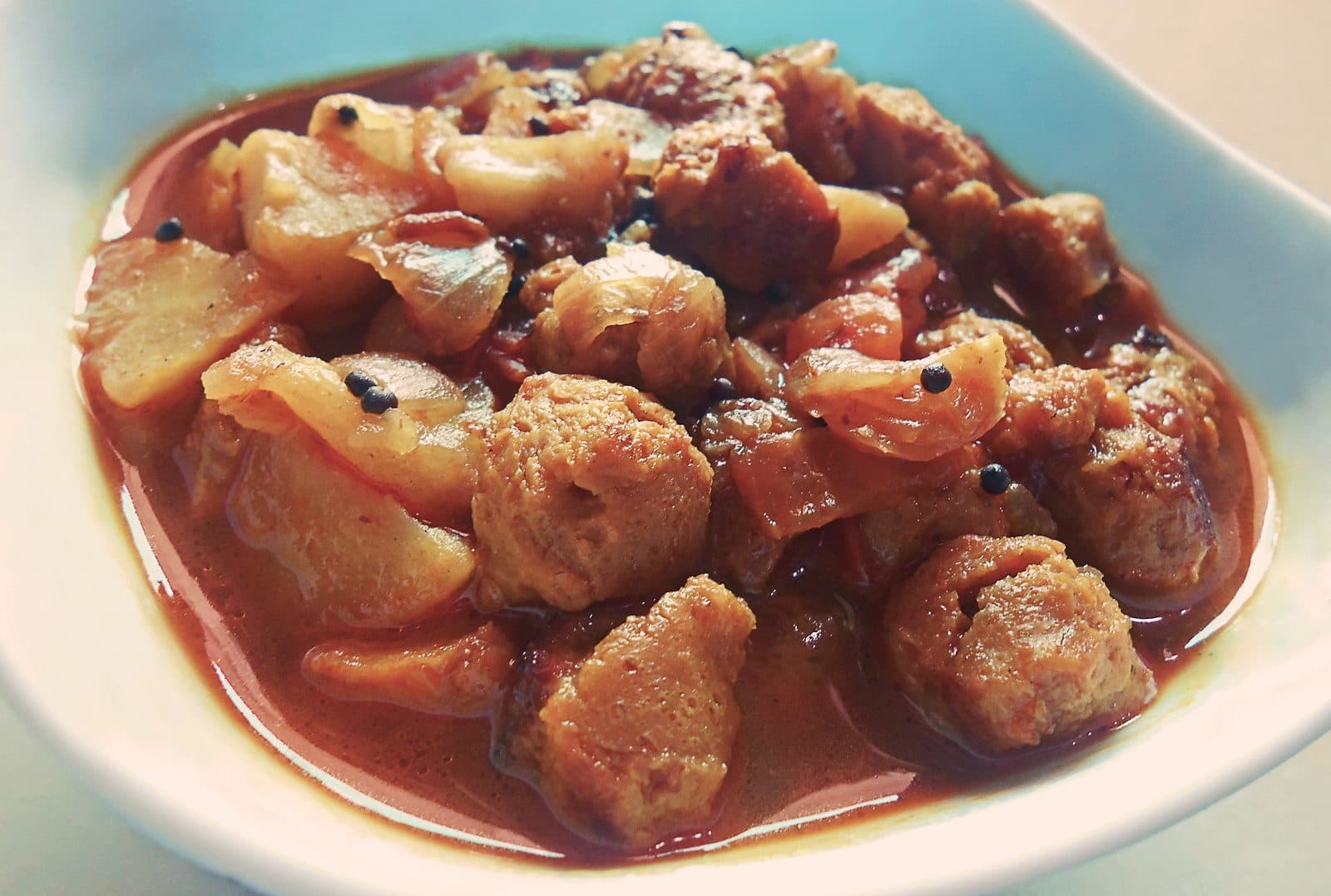 Close-up of soya chunk curry with potatoes and onions in a white bowl